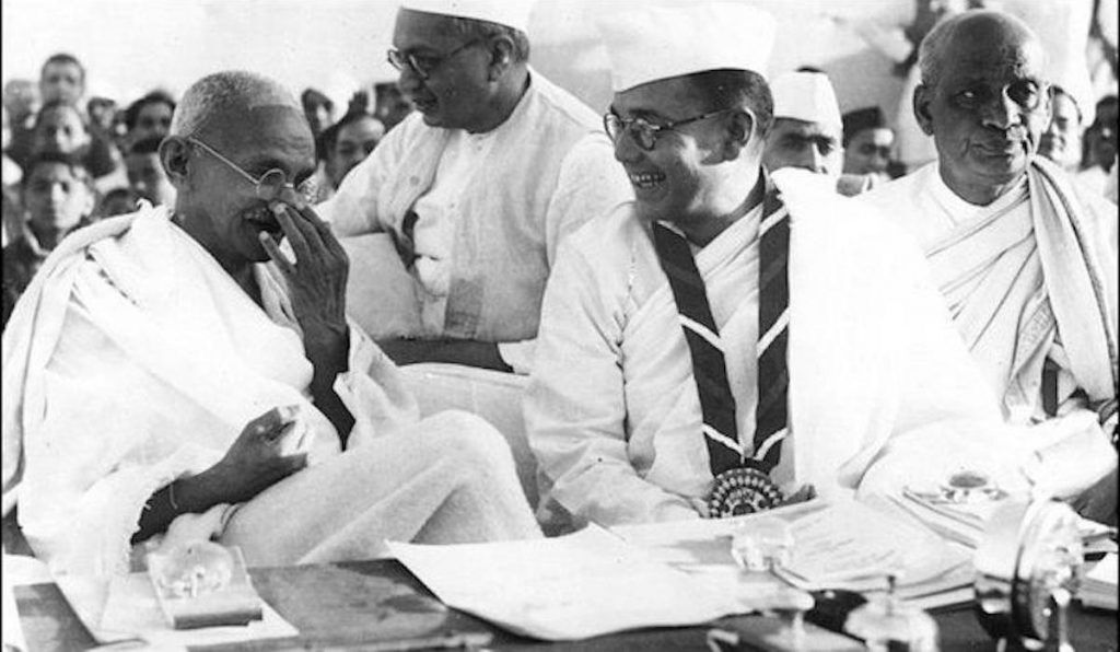 Членове на Индийския национален конгрес (на преден план от ляво на дясно) Махатма Ганди, Босе и Валабхай Пател по време на 51-ия Индийски национален конгрес, 1938 г. Обществено достояние.