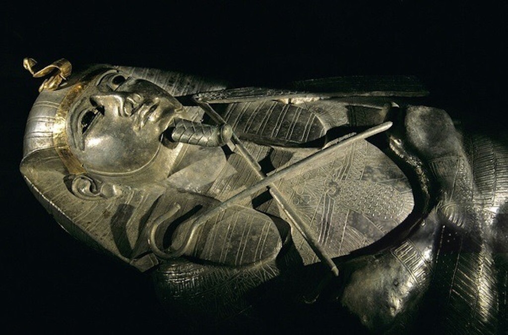 Le cercueil représente Psusenes I tenant un fouet et un sceptre.